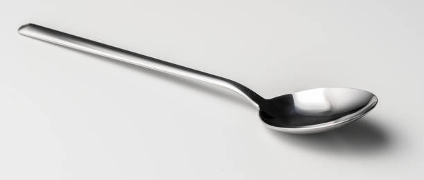 istock Silver dessert spoon cutlery on grey background 2203221034