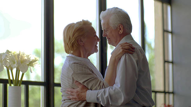istock Smiling elderly woman and man dancing at home 2203222637