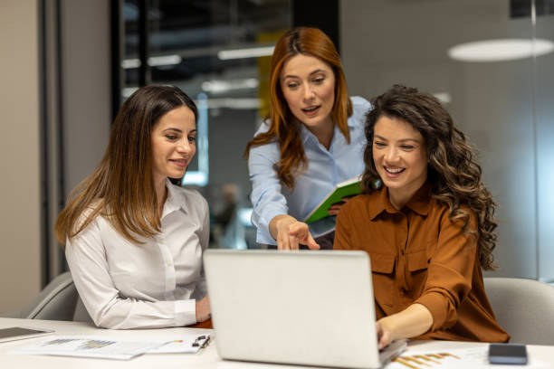 istock Businesswomen collaborating on laptop in modern office 2203224401