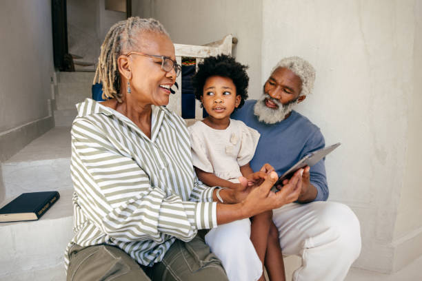 istock A happy multigenerational family sits together on a bright porch, sharing laughter while exploring something on a tablet. 2203225305