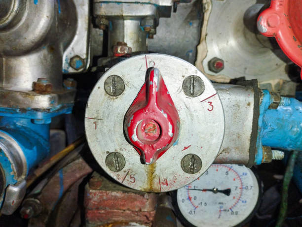 istock The valve has an unusual flame-like shape. The panel has numerical markings from 1 to 5 and -0.7. In the background, industrial equipment with pipes and valves of various colors is visible. 2203226609