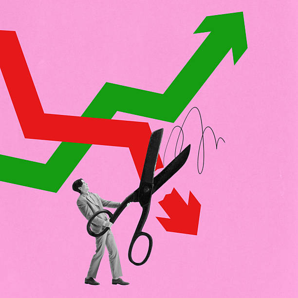 istock Man holding oversized scissors cutting downward red trend while green trend rises. Concept of market correction, financial restructuring 2203228872