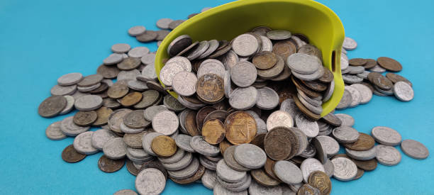 istock Metal coins have fallen from a bowl and scattered in a pile 2203230007