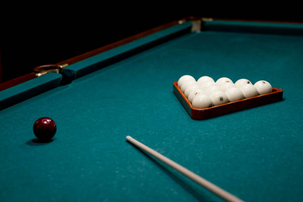 istock Russian billiards. Red and white balls are lying on a green billiard table. Spending time at home playing a hobby sports game. 2203236160