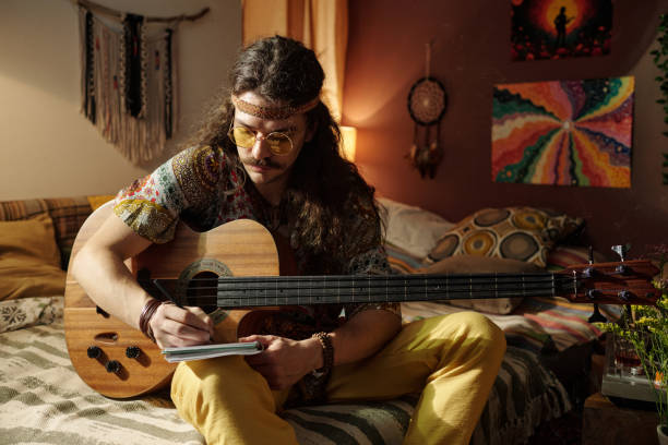 istock Writing Music on Acoustic Guitar in Cozy Room Setting 2203238987