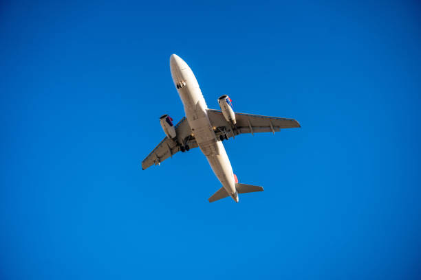 istock Underside view of an airplane flying through the sky, showcasing aviation technology, flight path, and the freedom of air travel. 2203240587
