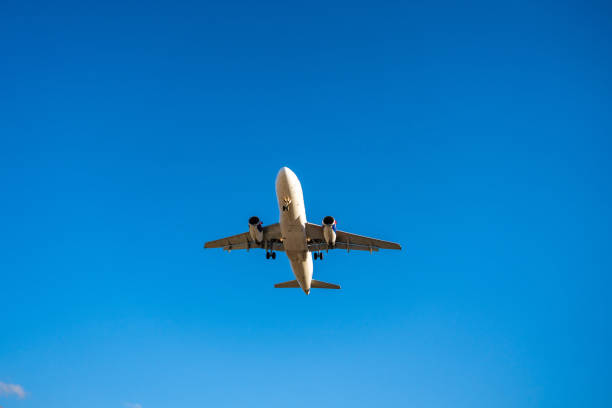istock Underside view of an airplane flying through the sky, showcasing aviation technology, flight path, and the freedom of air travel. 2203240596
