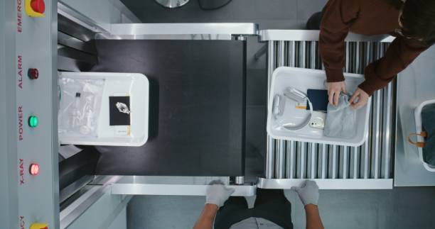 istock Top View on Diverse People, Passengers Putting Personal Items in Plastic Trays for Screening Procedures 2203244090