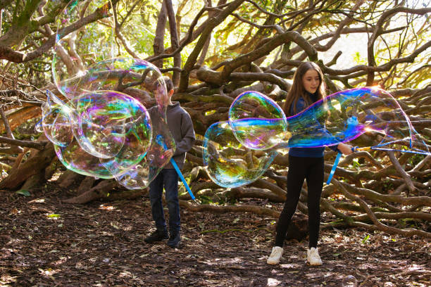 Siblings enjoying making bubbles outdoors.