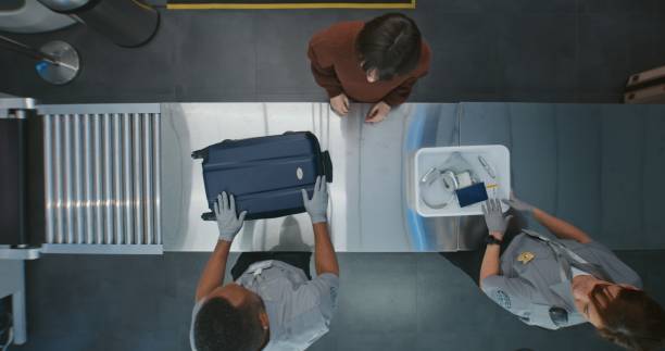 istock Queue of Diverse People, Passengers Putting Personal Items in Plastic Trays for Screening Procedure 2203249235