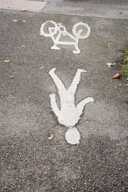Two funny preschool boys wearing helmets drawing a motorcycle with colorful chalk outdoors. Real life, real people moment of creative leisure, friendship, and playful childhood fun.