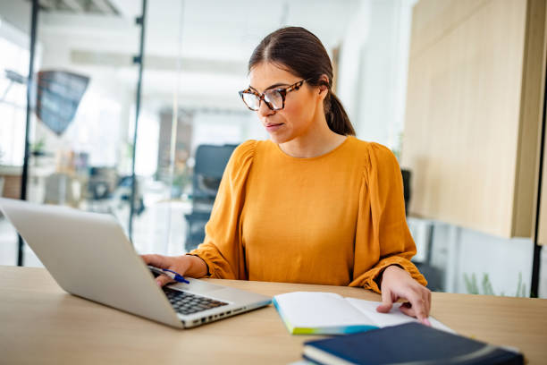 istock Young professional woman working diligently in a modern office setting during the day 2203252297