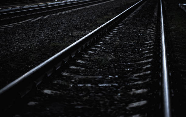 A moody view of railway tracks at dusk, showcasing symmetry and perspective in the environment.