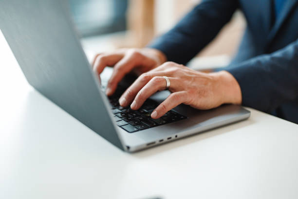 istock Businessman Typing on Laptop in Office Setting 2203253487