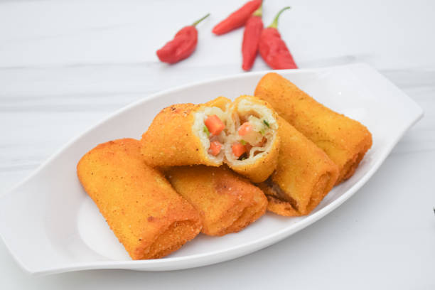 istock Delicious golden fried spring rolls are displayed with red chilies 2203255099