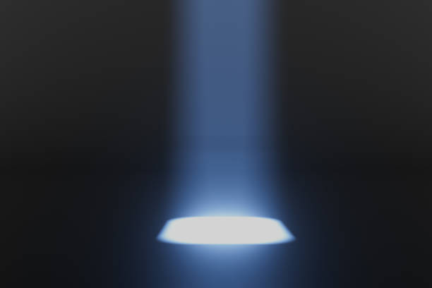 A dark room with a bright blue light shining on the floor. The light is coming from a small hole in the floor