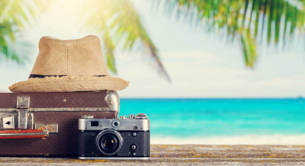 istock A bag with travel stuff, camera, and sun hat placed on a table 2203256589
