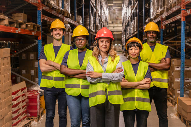 istock Warehouse workers smiling with arms crossed in distribution center 2203257654