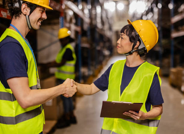 istock Warehouse workers shaking hands after reaching an agreement 2203257805