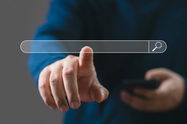 istock A person interacts with a transparent search bar interface, symbolizing digital search and technology innovation. Blurred background for focus. 2203258154