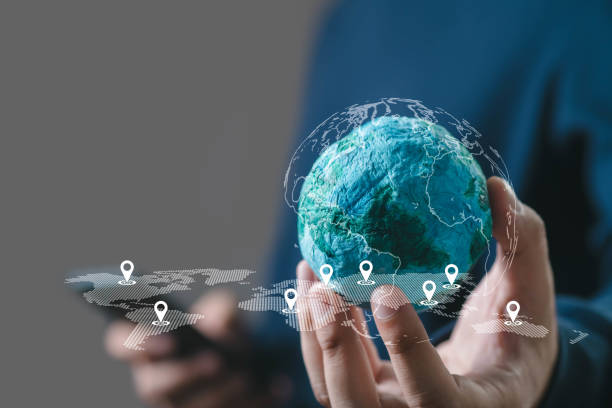 Person holding digital globe with location markers, representing global connectivity and technology. Hands, virtual, conceptual imagery in tech context.