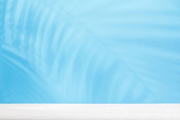 istock Template with empty table and wall with natural plant shadow and sunny glare 2203258255