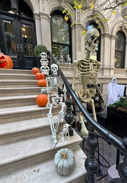 istock Spooky Stoop: Halloween Pumpkins and Skeletons on a Brownstone 2203258542