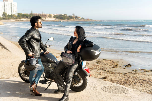 istock Bikers couple talking near motorcycle on the beach 2203259554