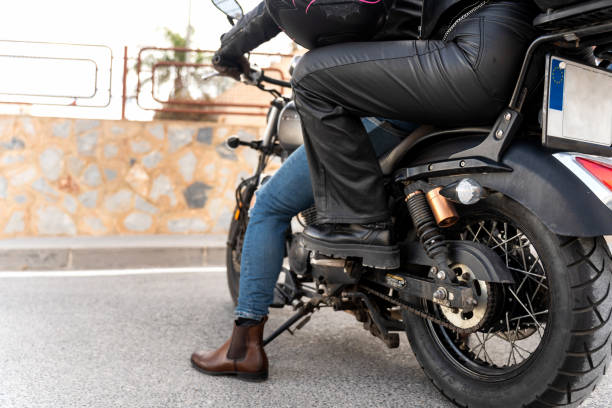 istock Biker wearing leather pants and boots, riding a motorcycle on asphalt road 2203259558