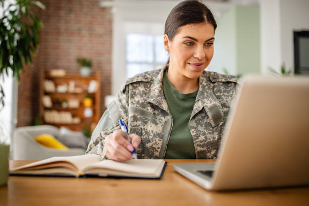 istock Young woman in military uniform working at home while using technology and studying 2203259990