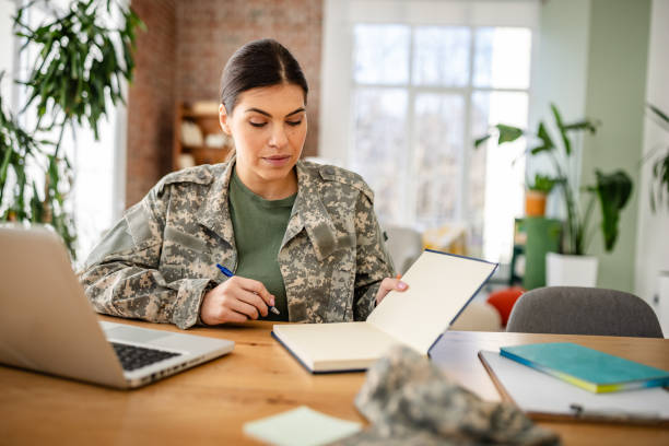 istock Young woman in military uniform working from home, focused on tasks in a modern office space 2203260203