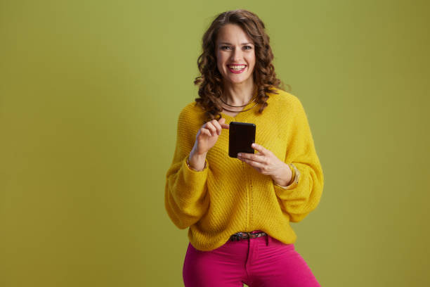 istock smiling fit woman using smartphone isolated on green 2203261821