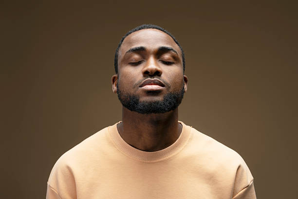 Young man meditating with closed eyes and neutral expression
