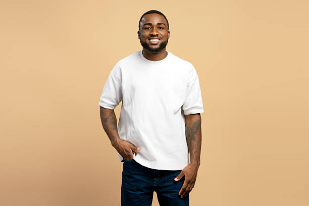 istock Confident young man smiling with hands in pockets wearing white t shirt 2203261977
