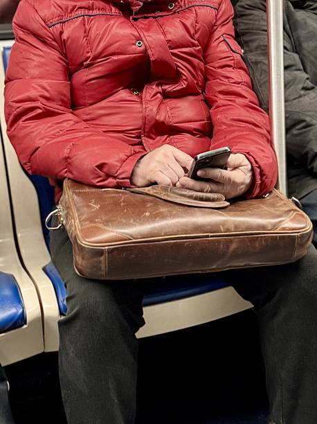 istock Unknown male passenger in a bright red jacket uses a smartphone while sitting comfortably on public transport 2203262947