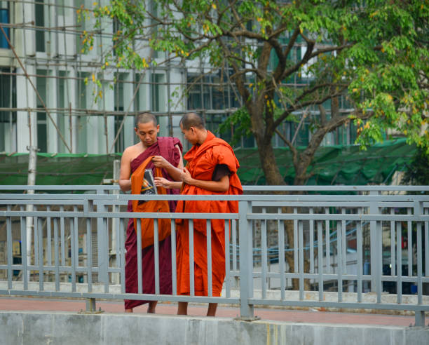 Yangon, Myanmar - Feb 1, 2017. Buddhist monks standing and relaxing at city park in Yangon downtown, Myanmar.
