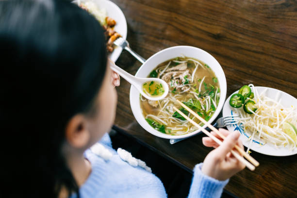 istock Woman Eating Pho Noodle Soup 2203263651