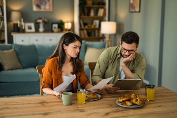 istock Displeased couple having problems managing expenses and paying bills at home 2203263800