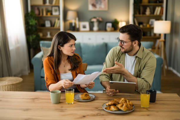 istock Displeased couple having problems managing expenses and paying bills at home 2203263856
