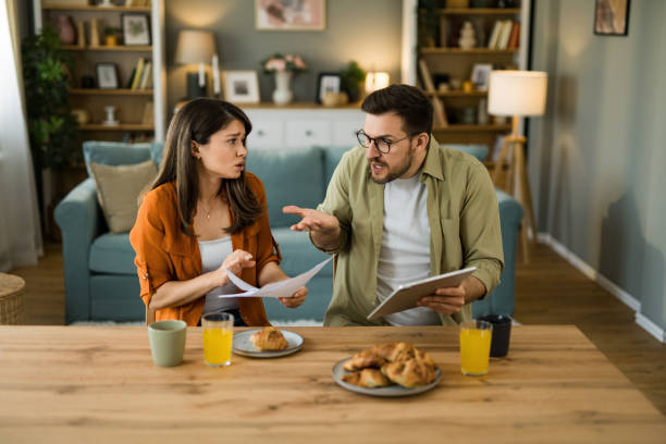 istock Displeased couple having problems paying their bills at home 2203264057