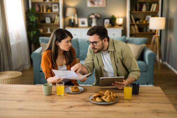 istock Displeased couple having problems paying their bills at home 2203264618