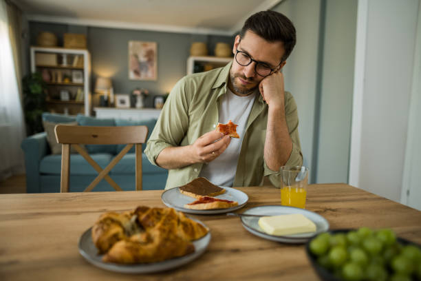 istock Depressed man eating breakfast alone at home 2203266822