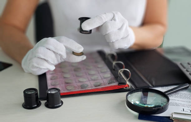 Examine vintage coins using magnifying glass and preservation tools during a meticulous collection process concept