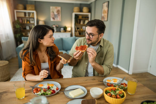 istock Couple eating breakfast together and talking at home 2203267417