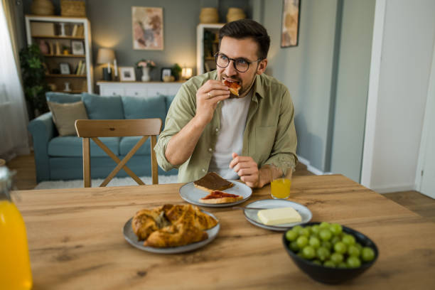 istock Man eating breakfast at home 2203267465