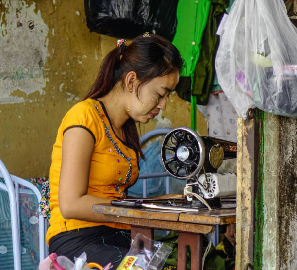 Yangon, Myanmar - Feb 1, 2017. A woman tailor working at old house in Yangon, Myanmar.