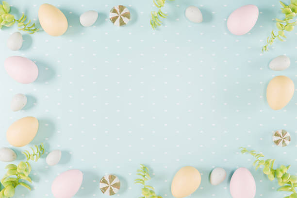 istock Easter themed arrangement of colorful eggs and greenery on a light blue background. 3d rendering 2203268135