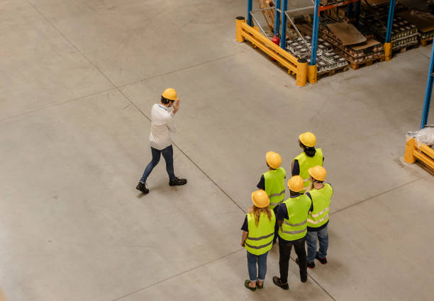 istock Warehouse manager guiding a group of workers during a safety briefing 2203268383