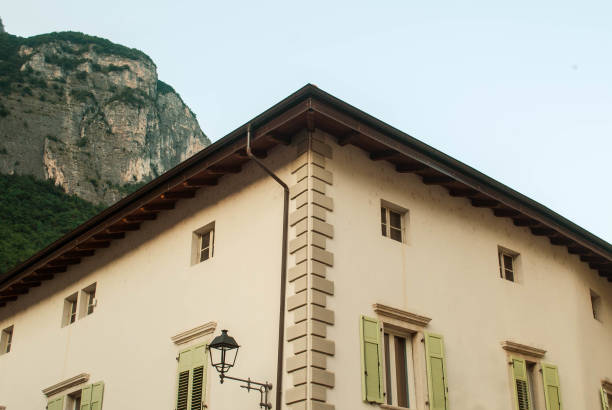 Corner of a typical house with green shutters in Mezzocorana, italy, with a mountain in the background