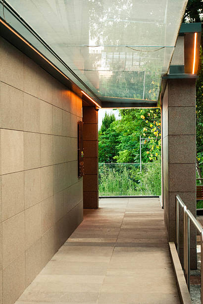 istock Modern corridor with glass ceiling leading to green park 2203270550